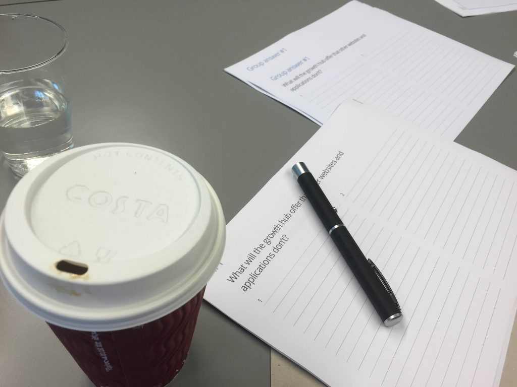 A coffee and some papers scattered on a table at London Growth Hub