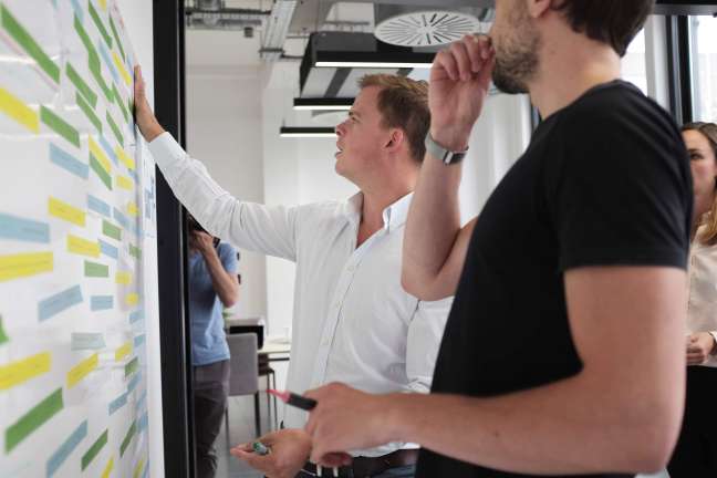 John works with sticky notes on a wall as part of a digital transformation project in our Shoreditch office