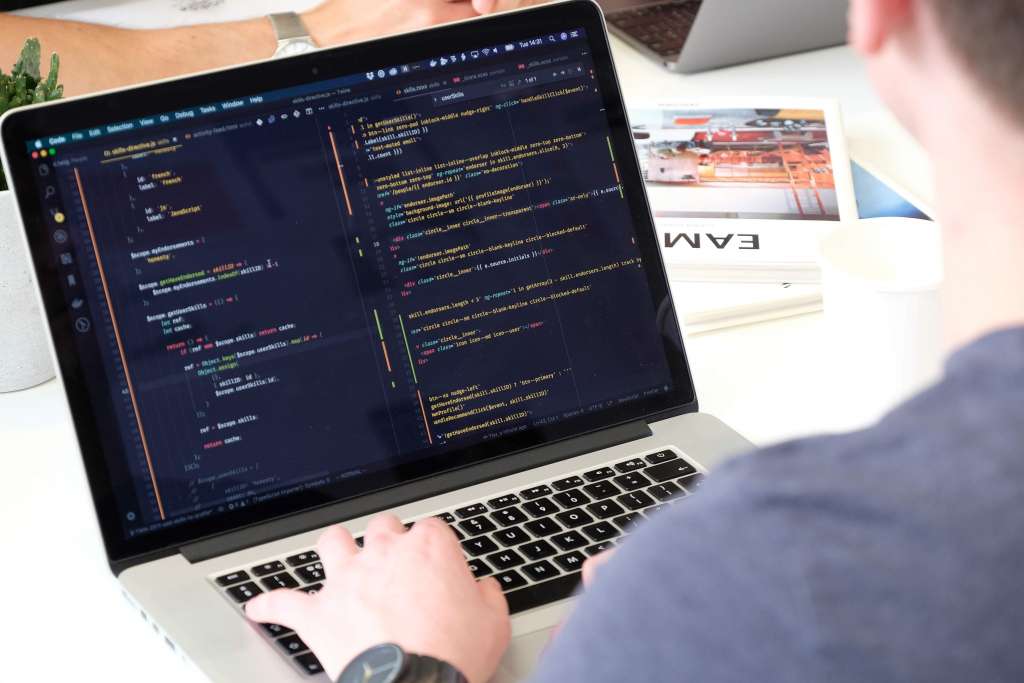 A developer codes a web application on a laptop