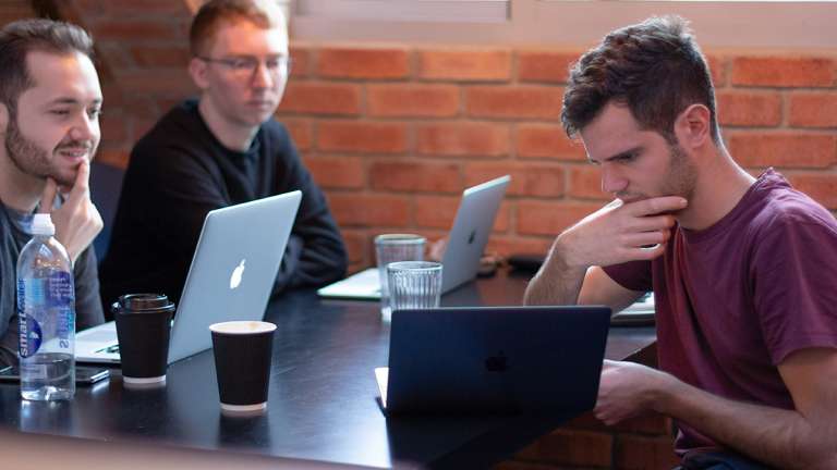 Three digital designers work on laptops at JAMS 2018