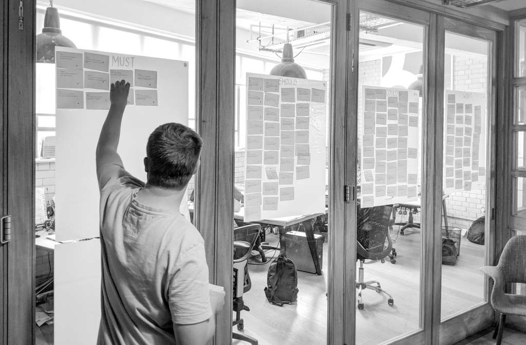 A person takes part in a MoSCoW method session in an office.