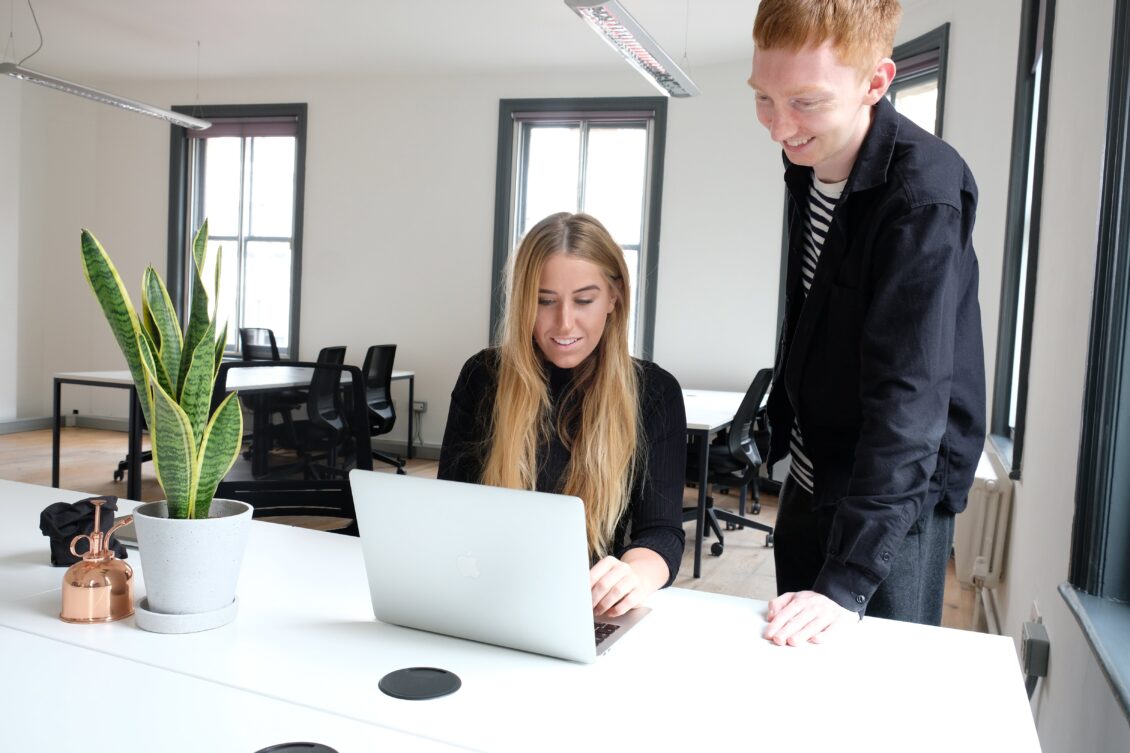 designer and developer discuss project whilst looking at laptop