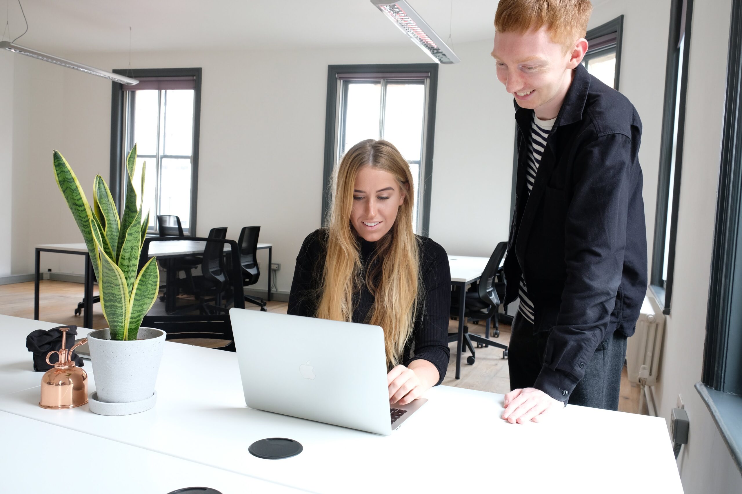designer and developer discuss project whilst looking at laptop