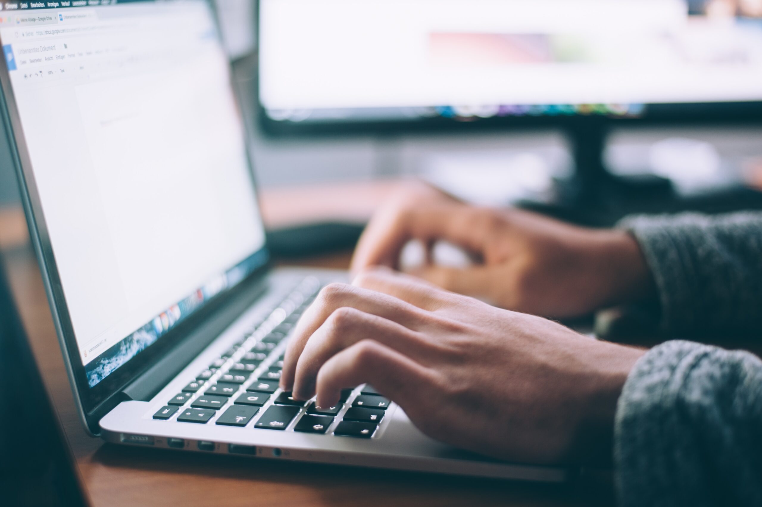 A person types on the keyboard of a laptop