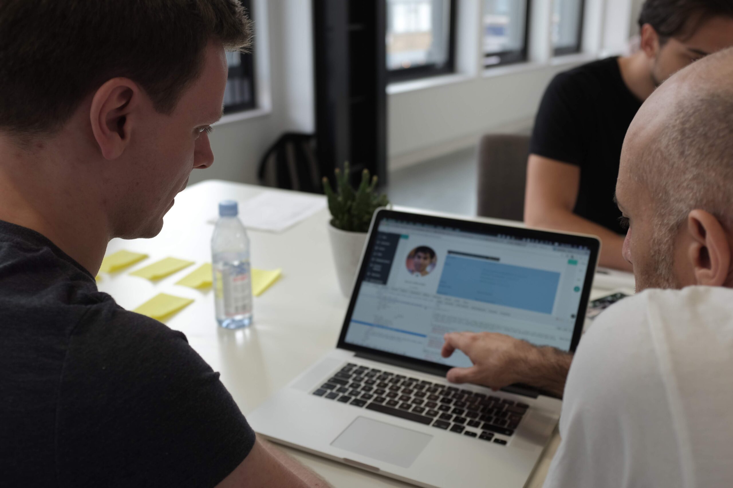 Two people work on QA testing at a laptop during a digital consultancy phase