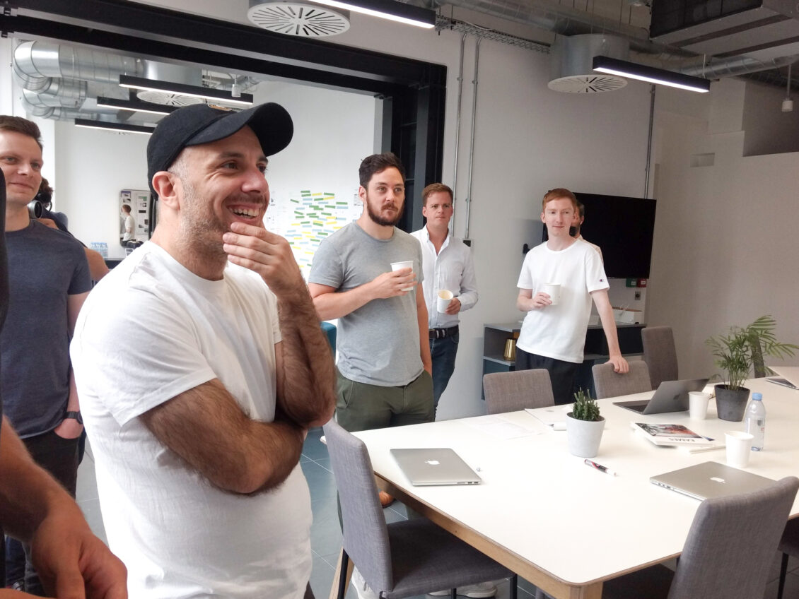 A team stand around and watch a presentation