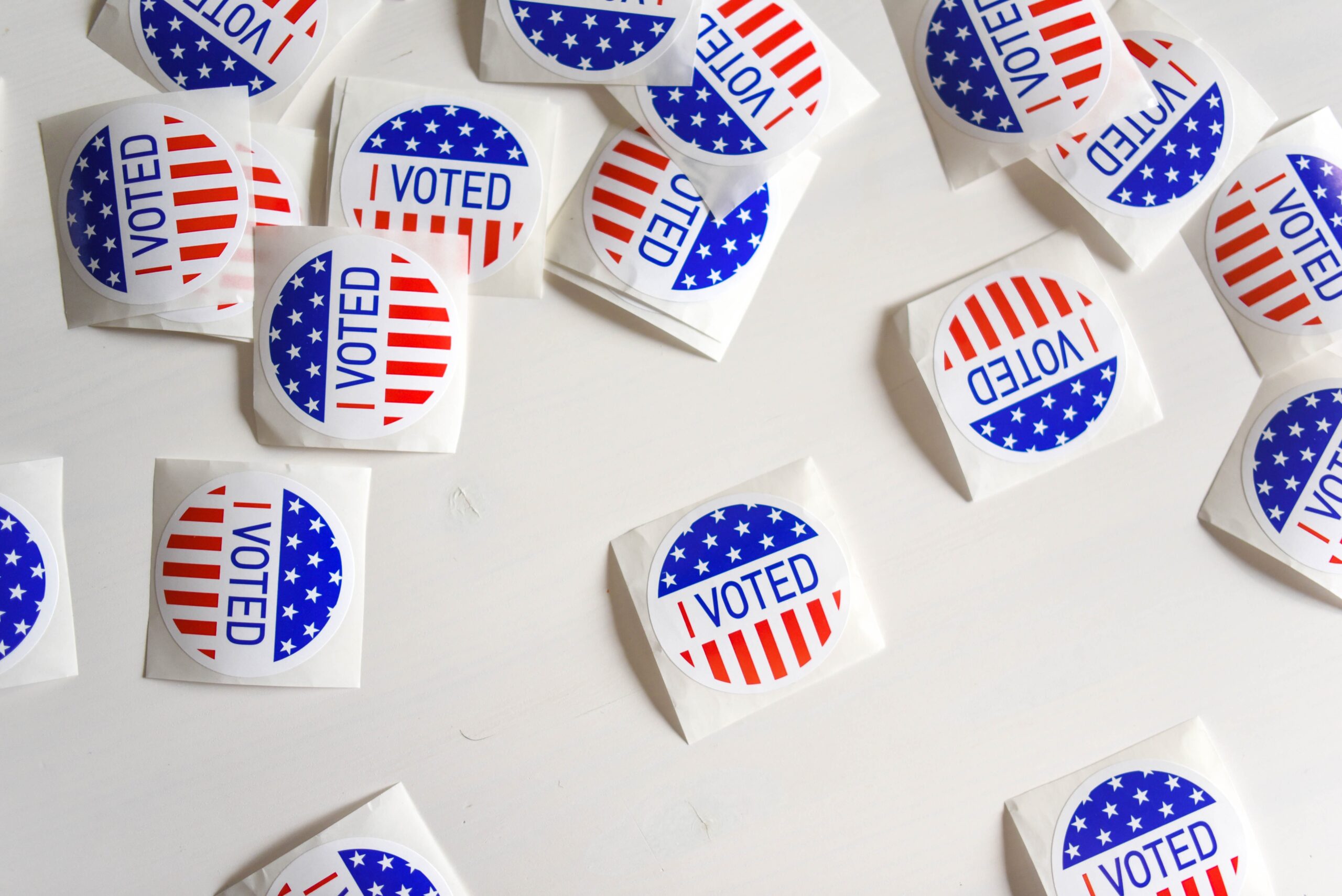 Stickers saying 'I Voted' on them are scattered on a table