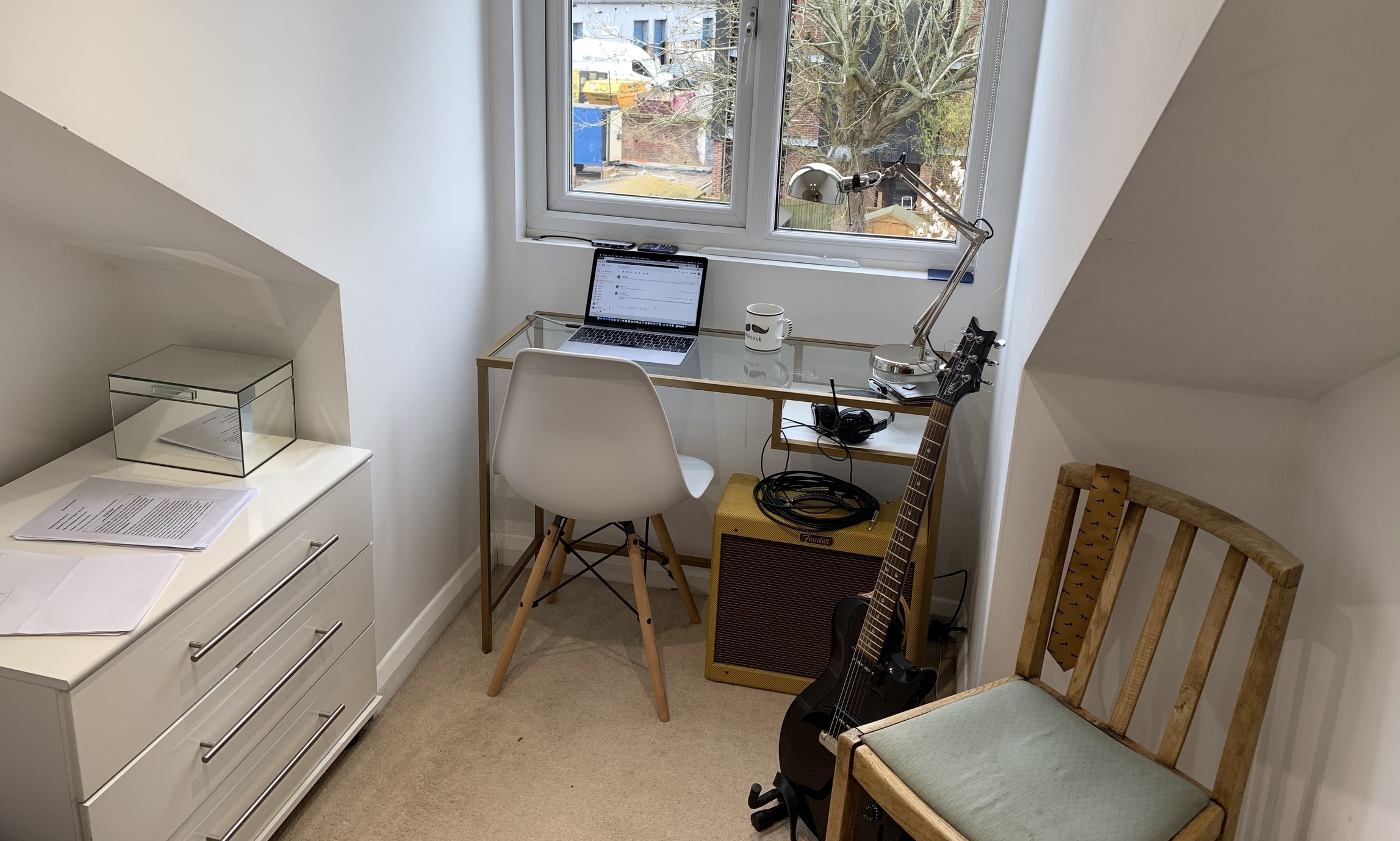 An example working from home desk with a chair and a guitar