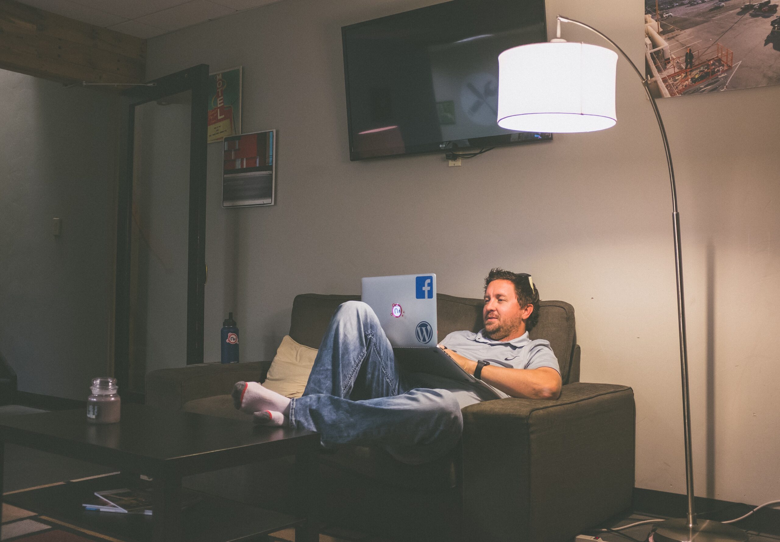 A man works from home on his sofa with a laptop