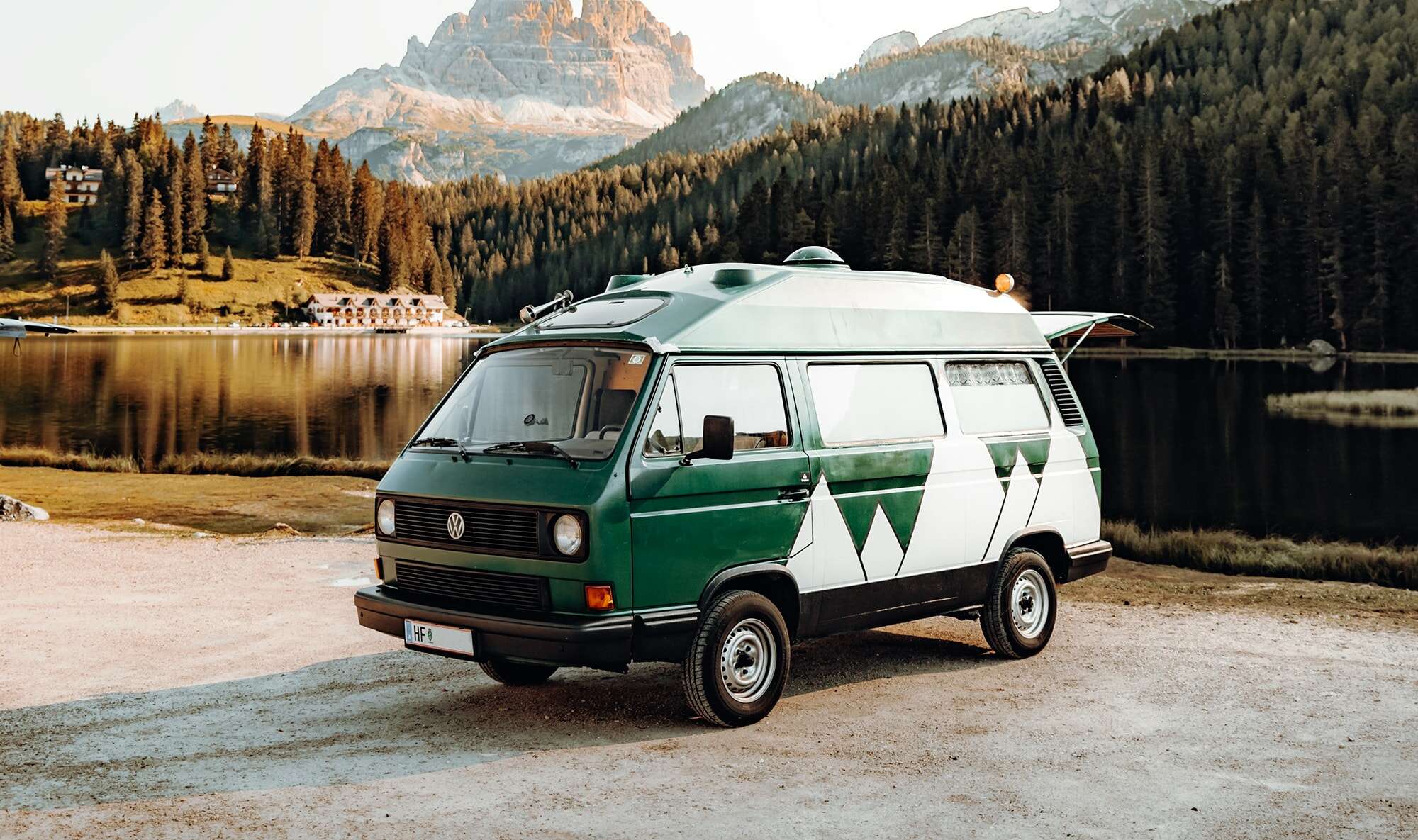 A green camper van parked in a park