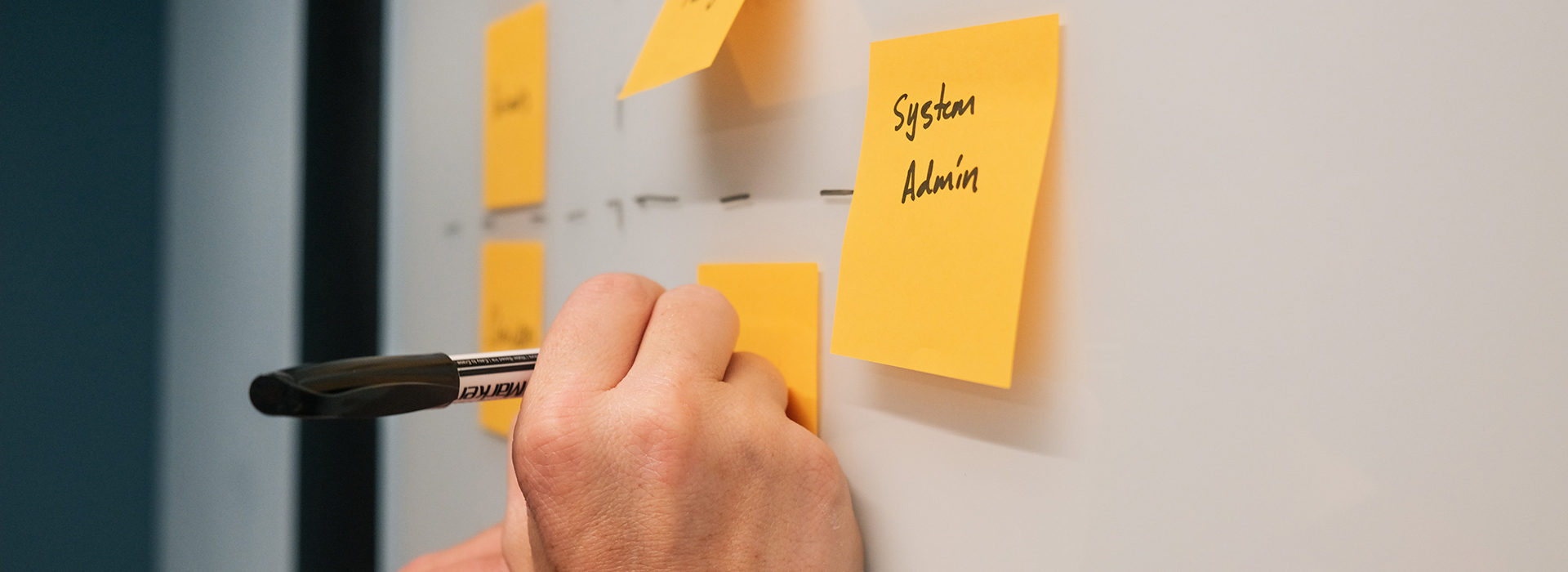 A person writes on a sticky note as part of a research process